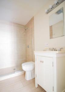 a white bathroom with a toilet and a sink at Downtown Boston Nurses Welcome in Boston +4 photos