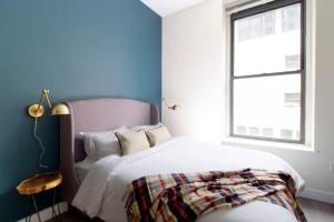 a bedroom with a white bed and a window at Studio walking distance to MGH and Tufts Medical in Boston