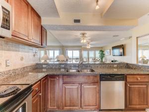 a kitchen with wooden cabinets and a sink at Surfside Six E Unit 5 in St. Augustine +26 photos
