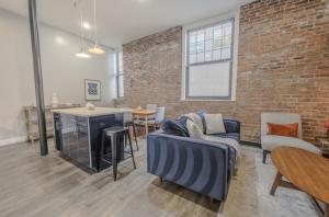 a living room with a couch and a brick wall at Unbeatable Location 4 bed Loft Parking Optional in Boston +8 photos