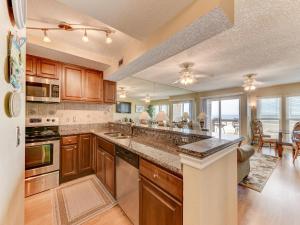 a kitchen with wooden cabinets and a large counter top at Surfside Six E Unit 5 in St. Augustine