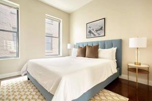 a bedroom with a large bed with a blue headboard at 2br 2ba FIDI Apt Keyless Entry Walk anywhere in Boston