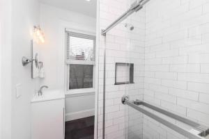 a white bathroom with a shower and a window at Cozy Central Fenway Studio in Boston