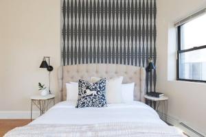 a bedroom with a white bed with a large headboard at Fantastic 1BR Apt in Financial District, Boston in Boston