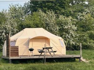 a tent with a table and a grill in a field at Walltree House Glamping - Bell Tent in Brackley