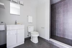 a white bathroom with a toilet and a sink at Spacious FIDI 2br 2ba Close to Everything in Boston