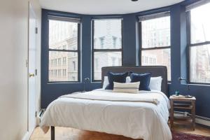1 dormitorio con paredes azules y 1 cama con almohadas azules en Awesome 2 bed 1.5 bath Downtown Apartment, en Boston