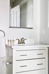 ein weißes Badezimmer mit Waschbecken und Spiegel in der Unterkunft Lovely FIDI Studio Close to Faneuil Hall in Boston