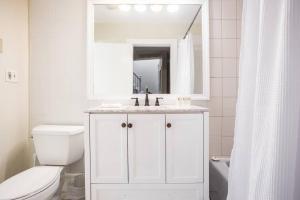 une salle de bain blanche avec un lavabo et des toilettes dans l'établissement Luxury 4BR 3BA in Fenway w Epic Roof Deck, à Boston