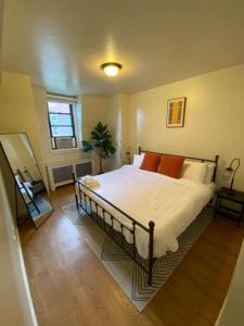 a bedroom with a large bed with orange pillows at Wonderful Fenway 3 Bed 2bath Steps from Fenway Park in Boston