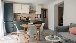 a kitchen and a living room with a table and chairs at Apartma Mia Nadiža in Kobarid