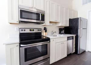 una cocina con estufa y microondas en Bright and Bold Loft Fast Wifi Downtown Boston, en Boston 3 fotos más