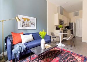 Una sala de estar con un sofá azul y una mesa. en Bright and Bold Loft Fast Wifi Downtown Boston, en Boston