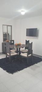 a dining room table with two chairs and a table with fruit on it at Alojamientos por aeropuerto villa olímpica estadio expofuturo in Pereira