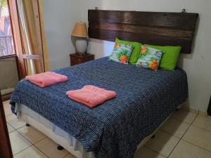 a bed with two pink pillows on top of it at Villa Chelsey in Valle de Ángeles +27 photos