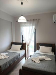 Dos camas en una habitación con ventana. en Marys Homes, en Lefkada