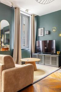 a living room with a couch and a table and a tv at Nancy Vieille Ville Stanislas in Nancy