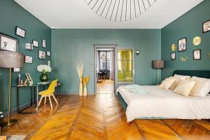 a bedroom with green walls and a bed with a yellow chair at Nancy Vieille Ville Stanislas in Nancy