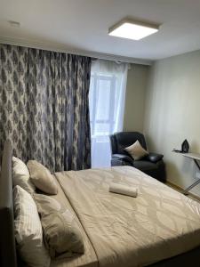 ナイロビにあるIndesign makumbi park, Muthama acces road 2-bedroom apartmentのベッドと椅子と窓のある寝室 +13枚の写真