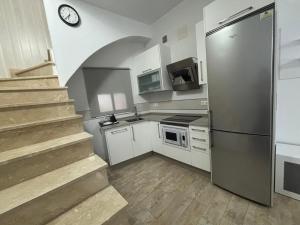 Una cocina con escalera y frigorífico de acero inoxidable. en Las Manuelas, en Arcos de la Frontera 6 fotos más