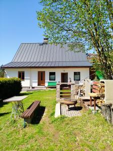 a house with a table and benches in front of it at Chalupa Emma in Tanvald +42 photos