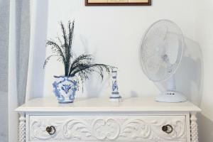 a white cabinet with a mirror and a vase on it at WelcomeBuddy - Casa do Moinho Garden & Sea Retreat in Ponta Delgada +11 photos