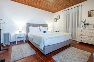 a bedroom with a large bed and a night stand at WelcomeBuddy - Casa do Moinho Garden & Sea Retreat in Ponta Delgada