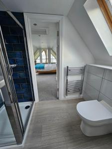 a attic bathroom with a toilet and a shower at Seabank House in Oban