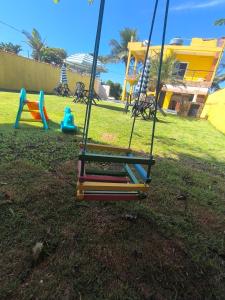 a swing in a park with a playground at Pousada Beira Mar Peruíbe in Peruíbe