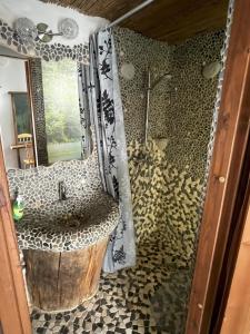 une salle de bain avec une douche avec un lavabo et un miroir dans l'établissement Koplimadisel talu, à Maeru