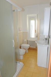 a white bathroom with a toilet and a sink at Casa da Mary in Iseo