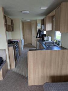 a small kitchen with a sink and a counter top at Cosy 8 Berth Caravan At Ty Mawr Holiday Park, North Wales Ref 86008D in Conwy