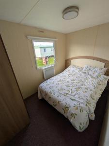 a bedroom with a bed and a window at Cosy 8 Berth Caravan At Ty Mawr Holiday Park, North Wales Ref 86008D in Conwy
