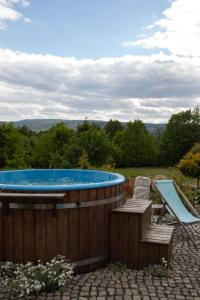 a hot tub with a deckchair and a chair next to at Bonaluti Adults - Azyl Dla Dorosłych in Mirsk