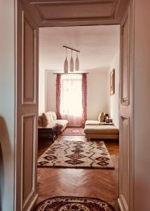 een open deur naar een woonkamer met een bank en een kleed bij Casa Young&Jung in Sibiu