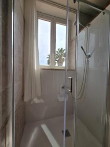 une douche avec une porte vitrée dans une salle de bain dans l'établissement Villa Habana, à Fonte Nuova 7 autres photos
