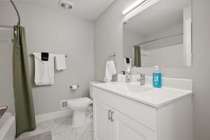 a white bathroom with a sink and a toilet at Serene & Modern Haven for Relaxation in Rochester Hills