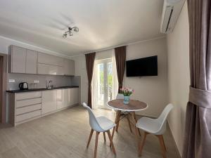 a kitchen with a table and chairs in a room at Studio apartment with heated pool in Kotor