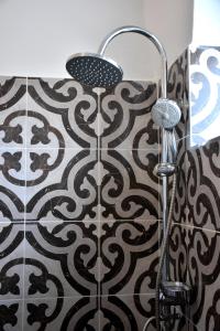 a shower in a bathroom with a black and white tile at Apartman Ládi in Veľký Meder