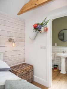 een slaapkamer met een bed en een bloemstuk aan de muur bij Garden Cottage, Cosy, Private, Short drive to beach in North Walsham