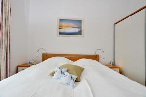 ein großes weißes Bett mit zwei Kissen darauf in der Unterkunft Ferienwohnung Strandkorb in Juliusruh