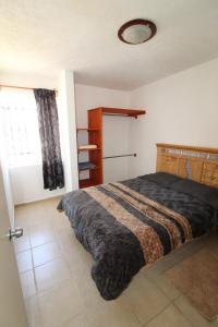 a bedroom with a bed and a window at White and Yellow Stone en San Miguel in El Santuario