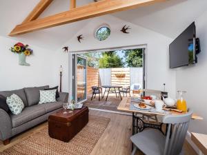 een woonkamer met een bank en een tafel bij Garden Cottage, Cosy, Private, Short drive to beach in North Walsham