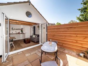 een tuinkamer met een tafel en stoelen op een terras bij Garden Cottage, Cosy, Private, Short drive to beach in North Walsham