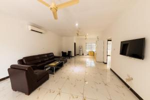 Una sala de estar con un sofá y un televisor de pantalla plana. en Sheesea Apartments, en Trofwi