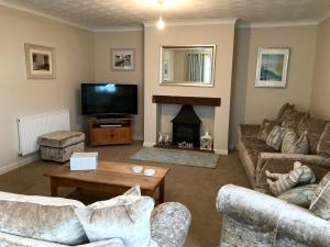 un soggiorno con due divani e un camino di Pen Y Frith Bungalow a Prestatyn