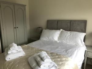 una camera da letto con un letto con asciugamani sopra di Pen Y Frith Bungalow a Prestatyn