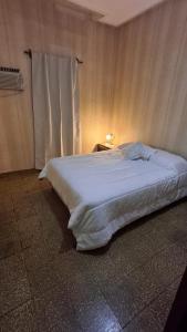 サン・ミゲル・デ・トゥクマンにあるDEPARTAMENTOS INDEPENDENCIaの部屋にある大きな白いベッドのある寝室