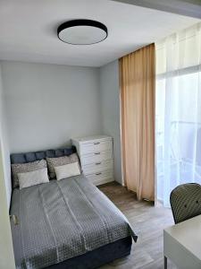a bedroom with a bed and a dresser and a window at 3 rooms 2 beds 1 sofa-bed apartment with garden in Kaunas