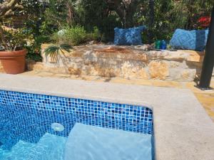a swimming pool in front of a stone wall at Villa AMore Radini with a private heated saltwater pool and private parking in Brtonigla